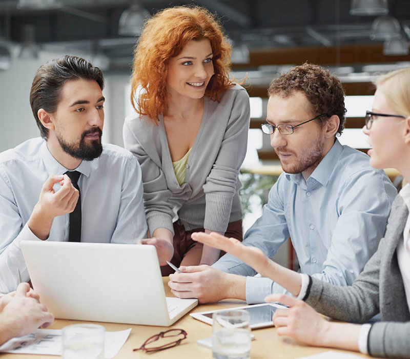 Equipo profesional colaborando alrededor de una computadora